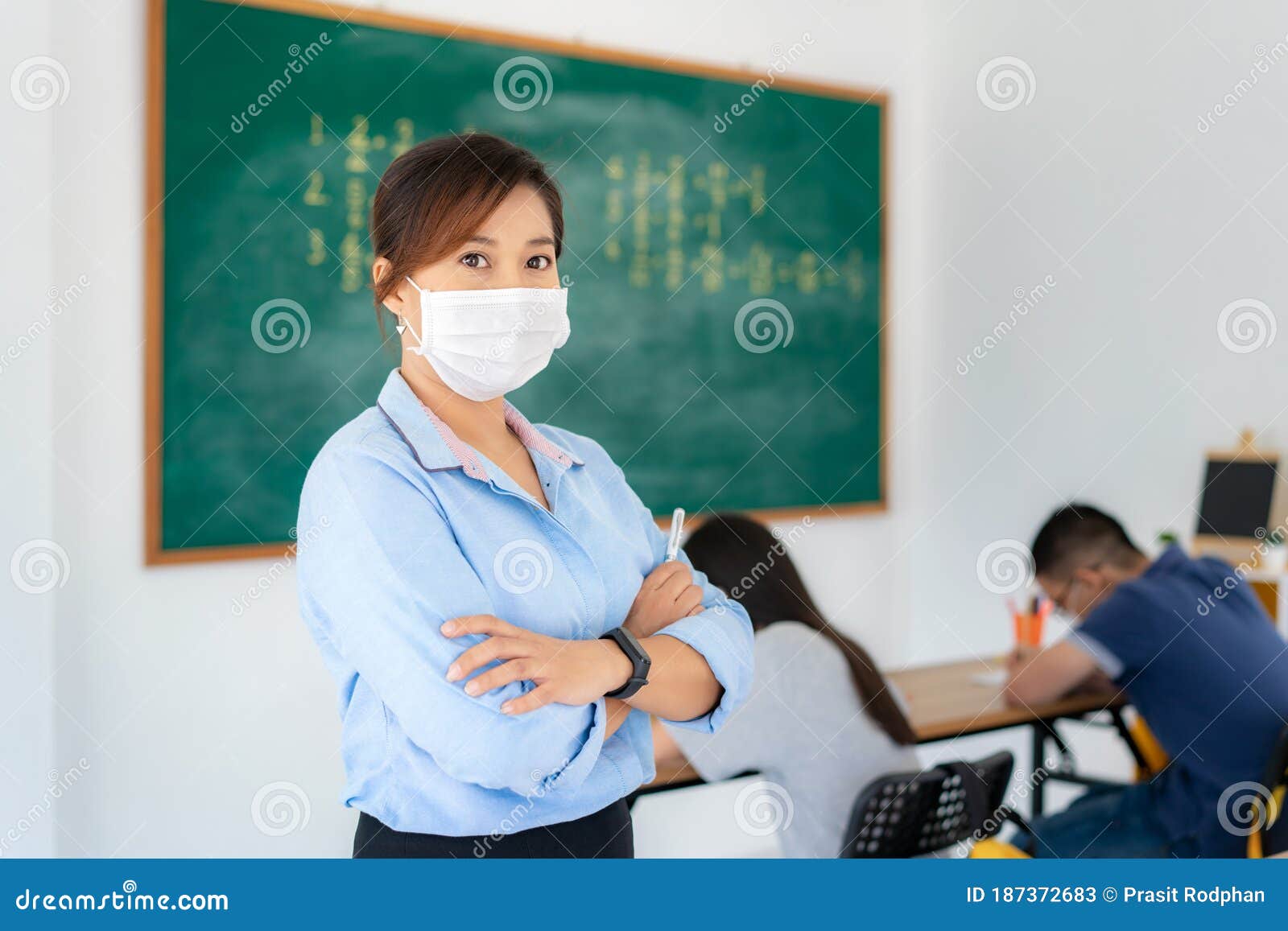 asian woman teacher wearing masks to prevent the outbreak of covid 19 in classroom with student while back to school reopen their