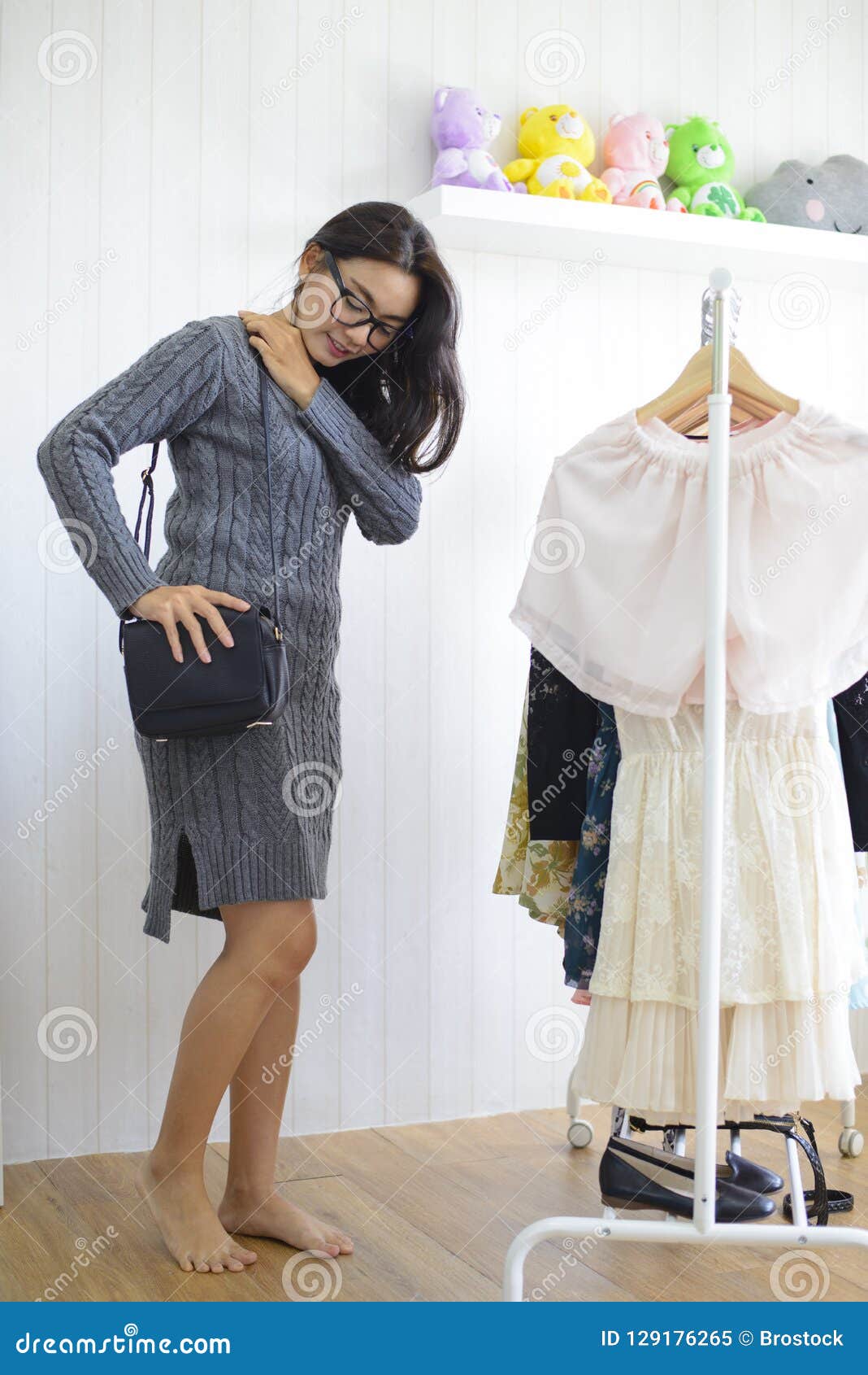 Asian Woman Trying On A Black Leather Bag In A Clothing Stor