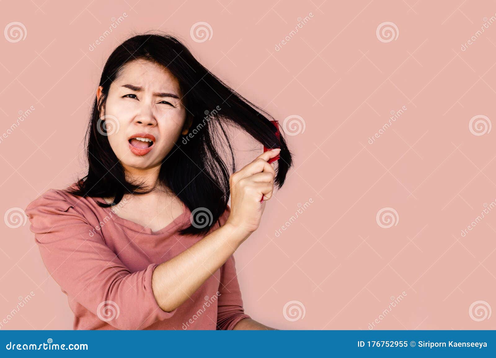 asian woman using comp brushing her dry damaged long hair