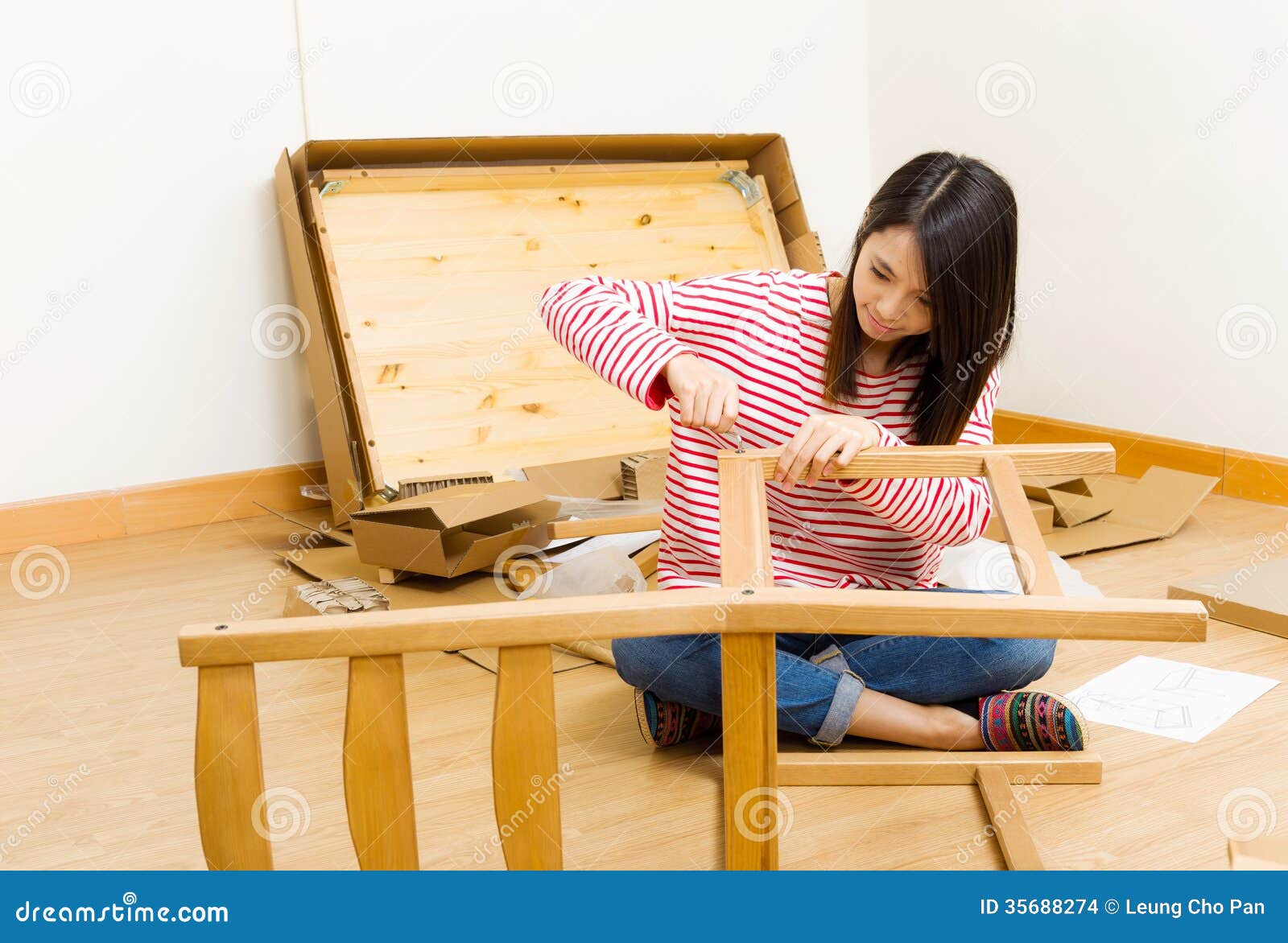 asian woman using strew driver for assembling furniture