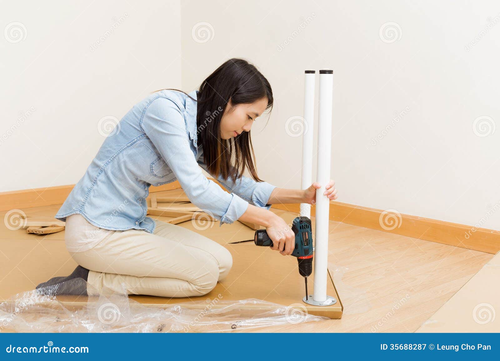 asian woman using strew driver for assembling furniture