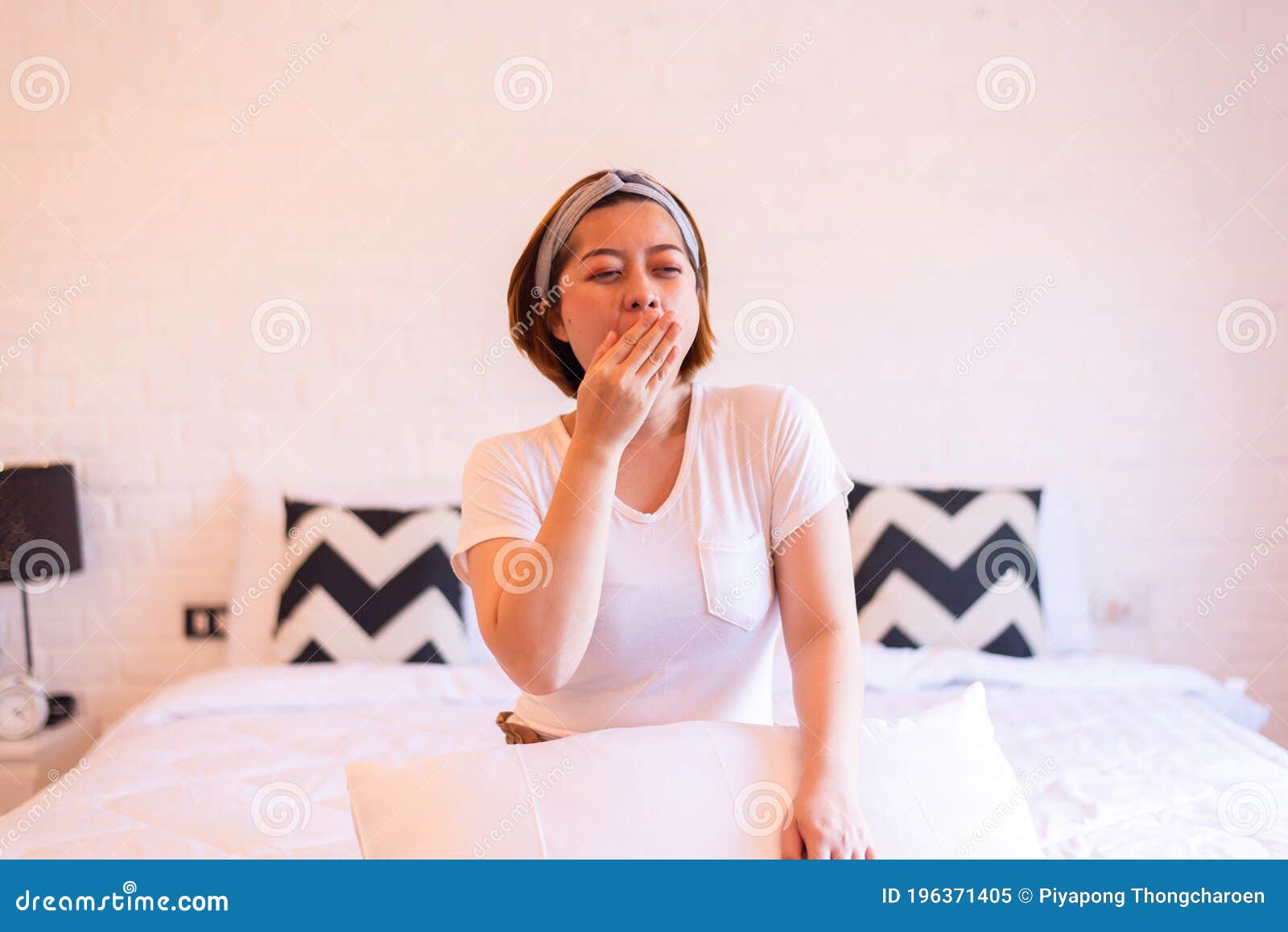 asian woman yawning on her bed and tired sleepy,female with symptoms sleepiness