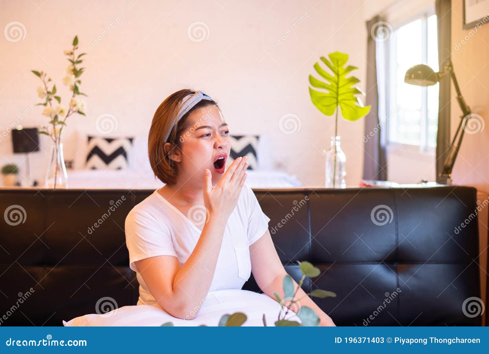 asian woman yawning during on sofa and tired sleepy,female with symptoms sleepiness