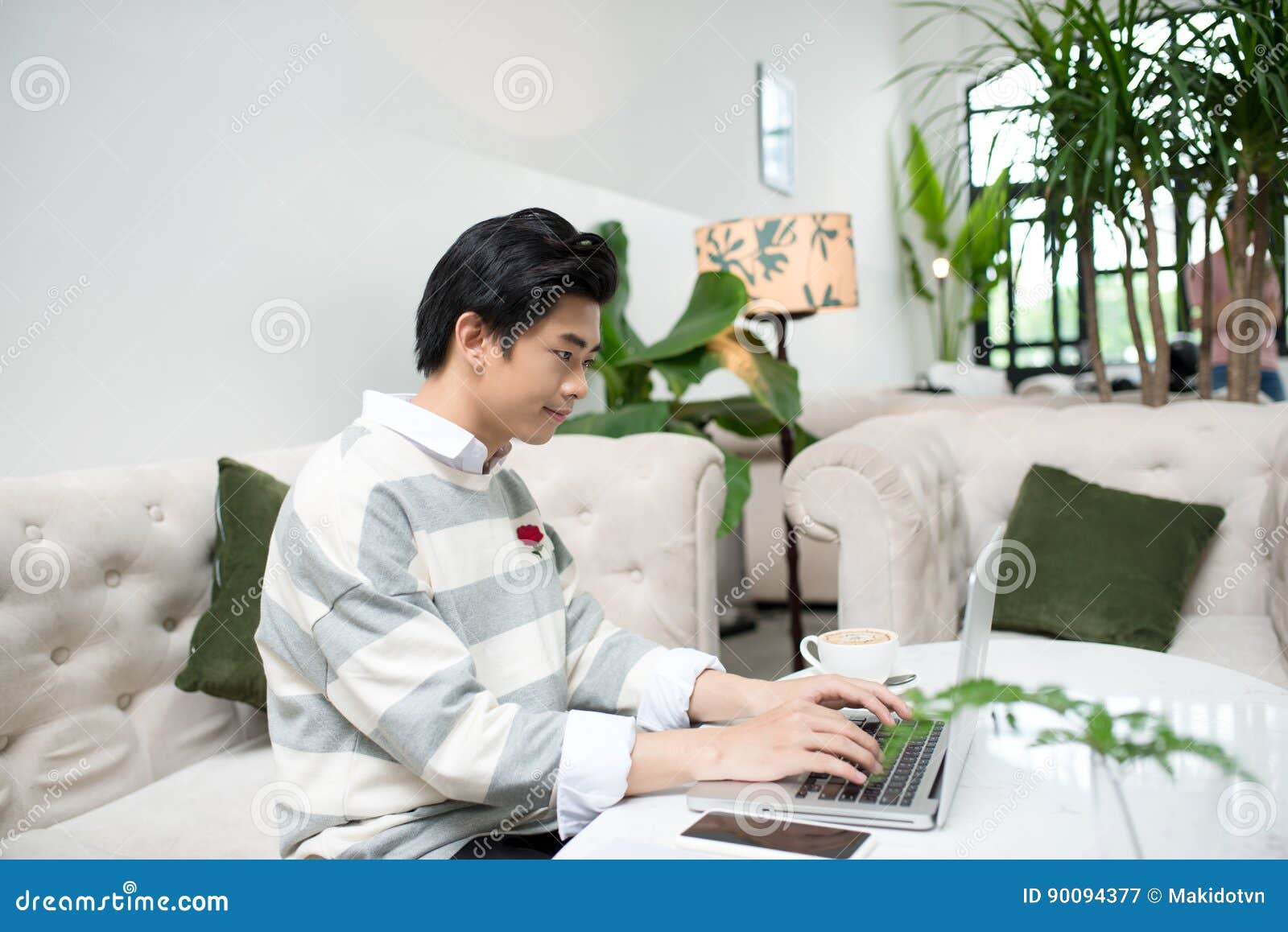 asian young business man working with laptop atthe city cafe.