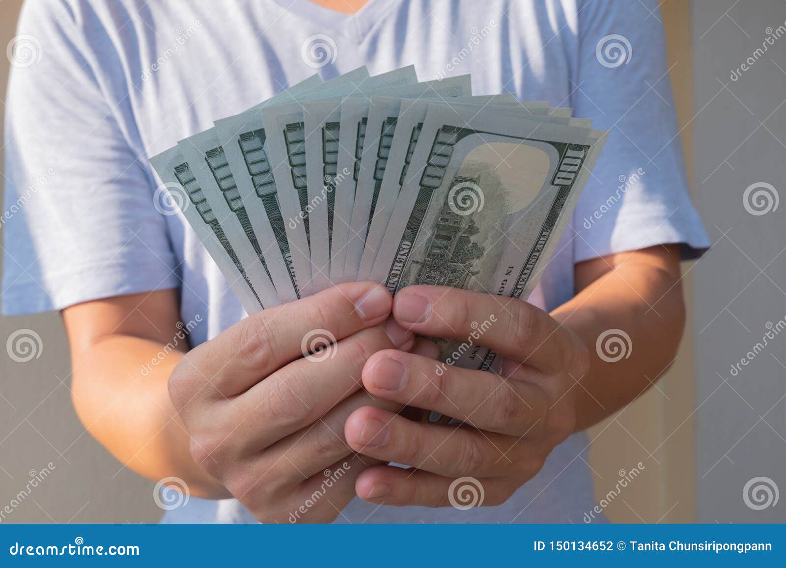 Asian man holding one hundred dollar bill. Wealthy and richness concept