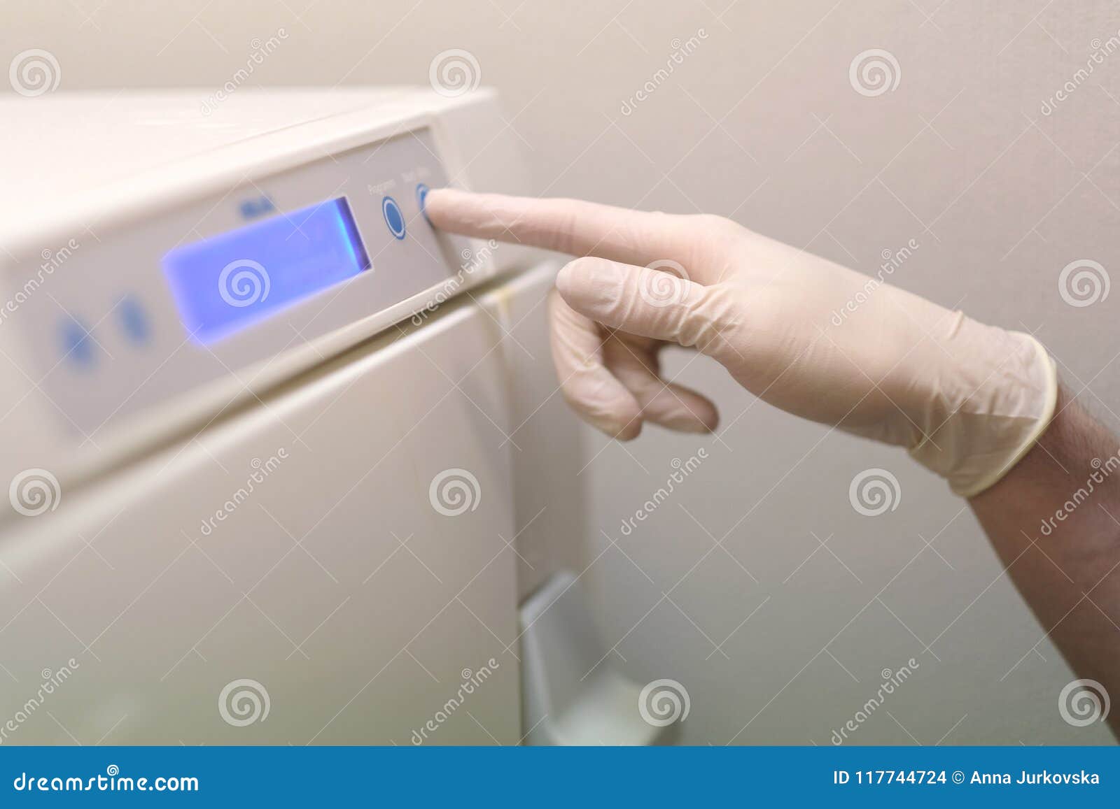 Assistant Dentist Chooses a Program in an Autoclave Stock Photo Image