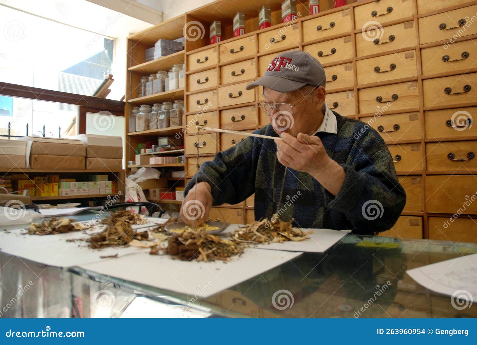Chinese Herbalist Weighs Herbs For Customer In Chinatown Oakland CA chinese-herbalist-weighs-herbs-for-customer-in-chinatown-oakland-ca