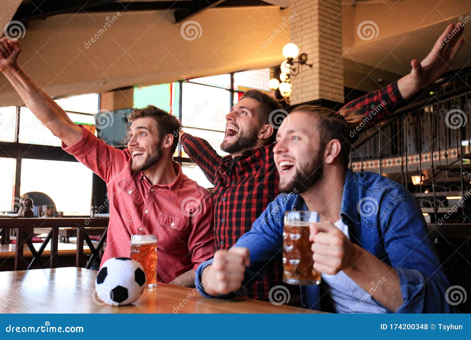 Amigos bebendo cerveja e assistindo jogo de futebol