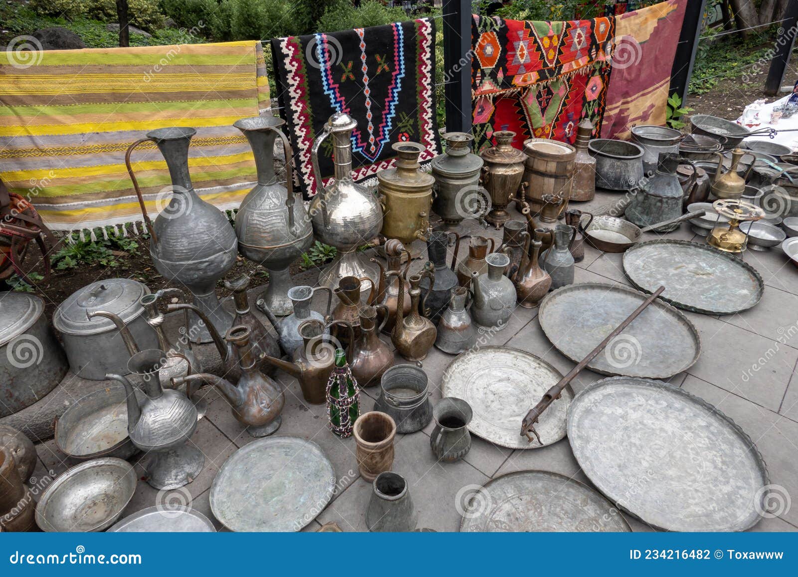 assorted copperware and rugs on flea market