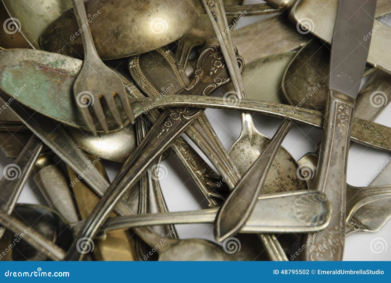 assorted tarnished antique flatware on white