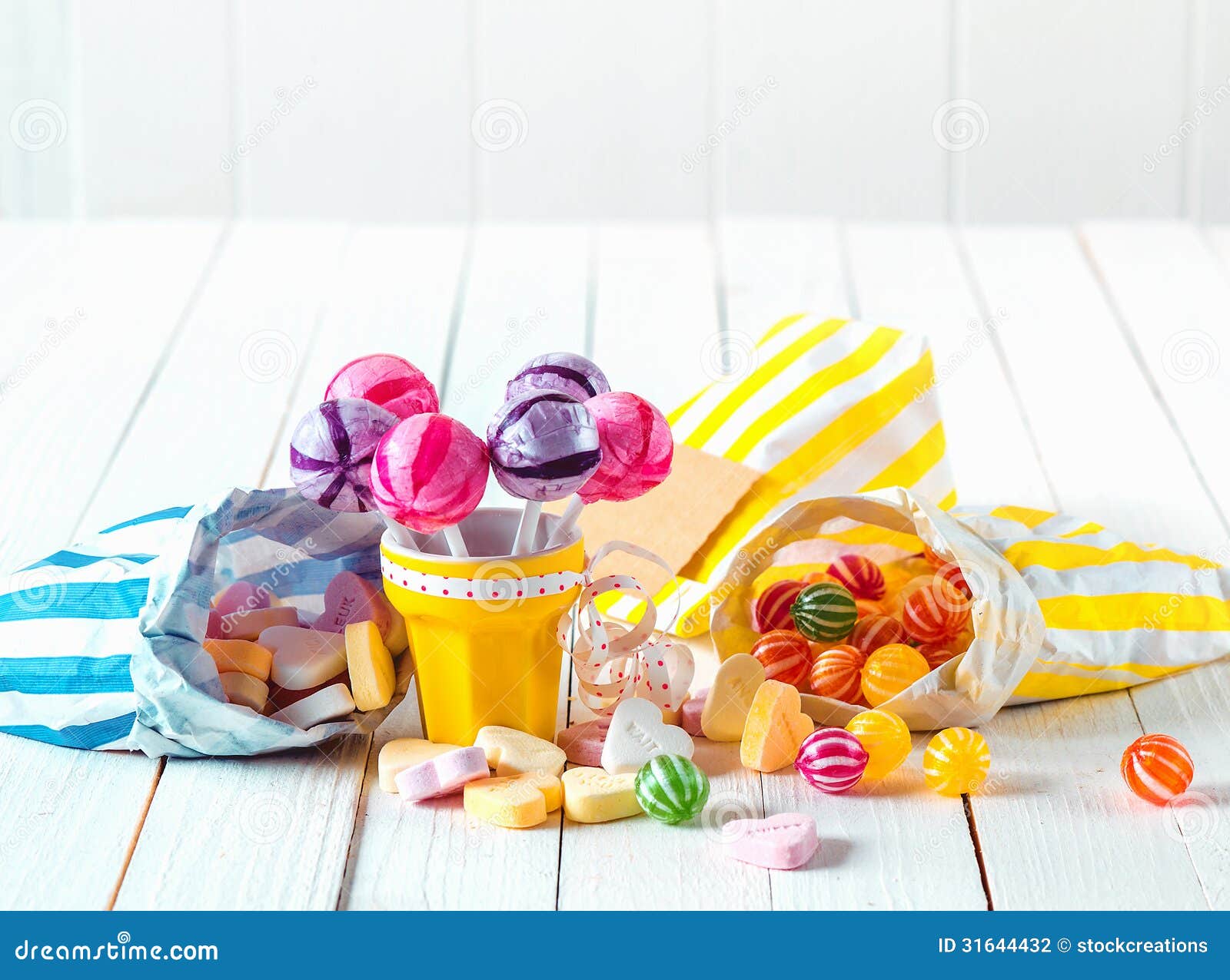 assortment of candies in bags and cup over a table