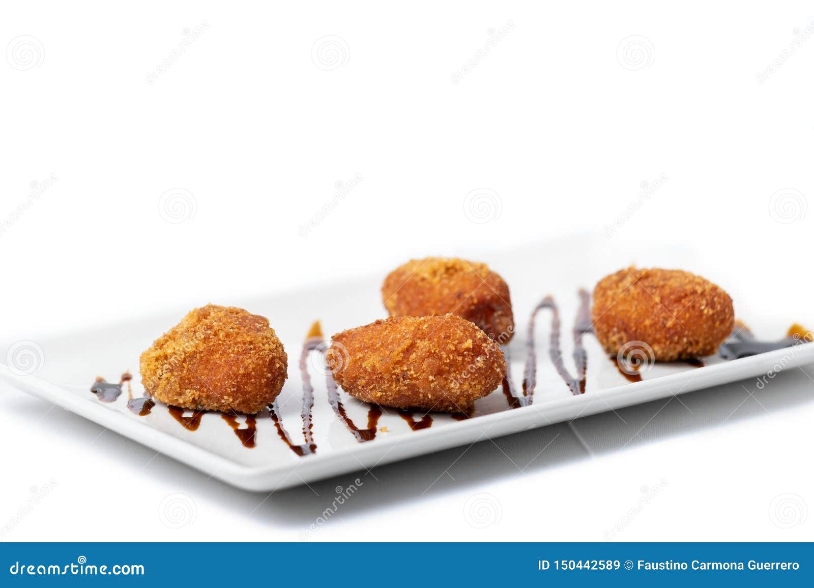 Assortment of Croquettes with a Vinaigrette on a White Rectangular