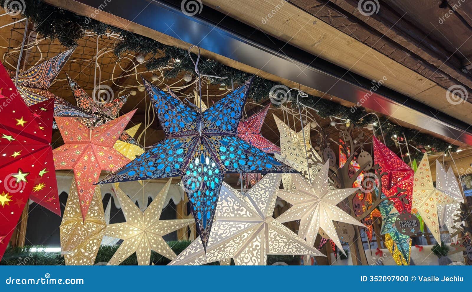 assortment of illuminated paper star lanterns at a christmas market