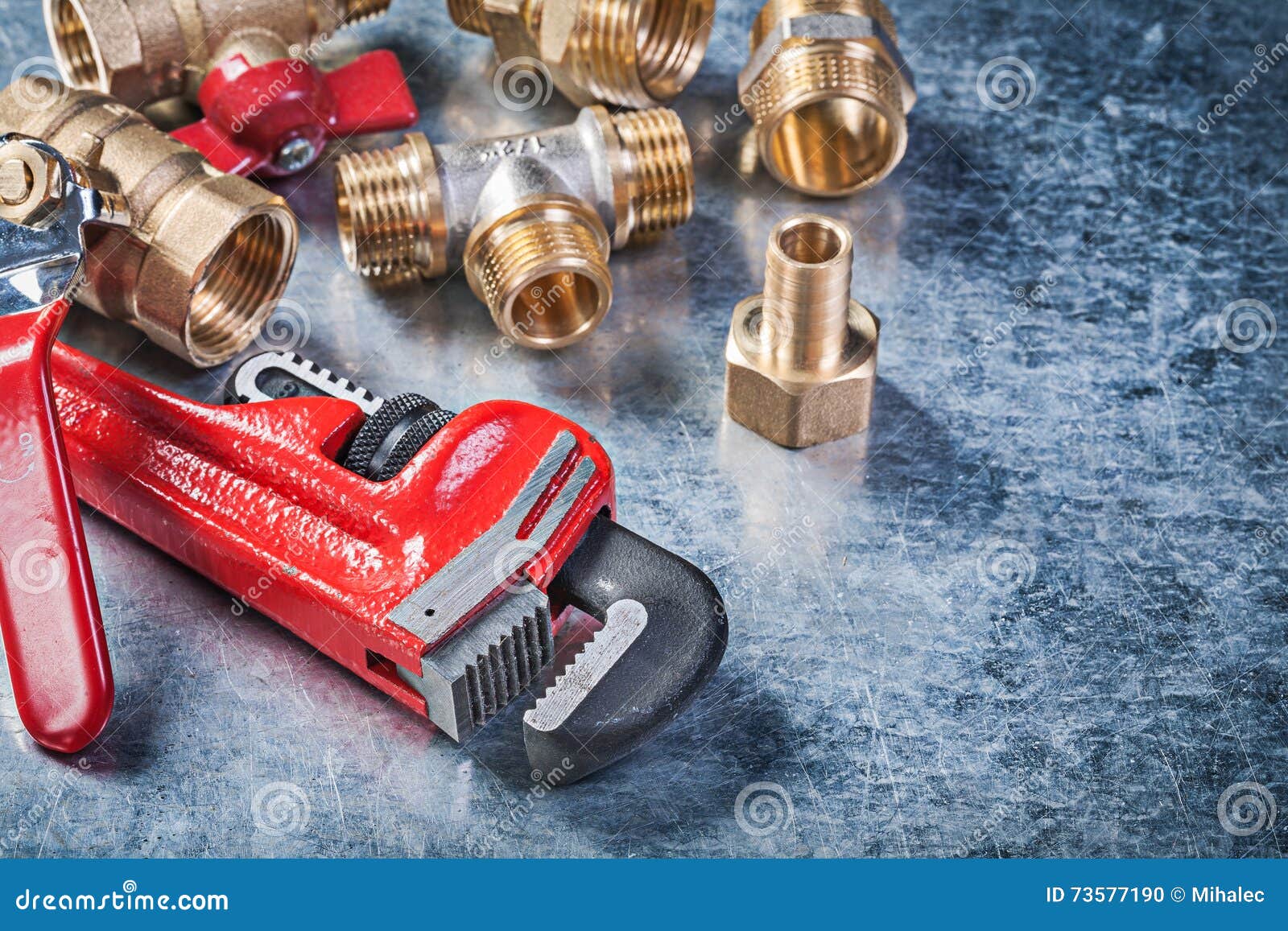 Assortment of Plumbing Brass Hardware on Metallic Background Con Stock