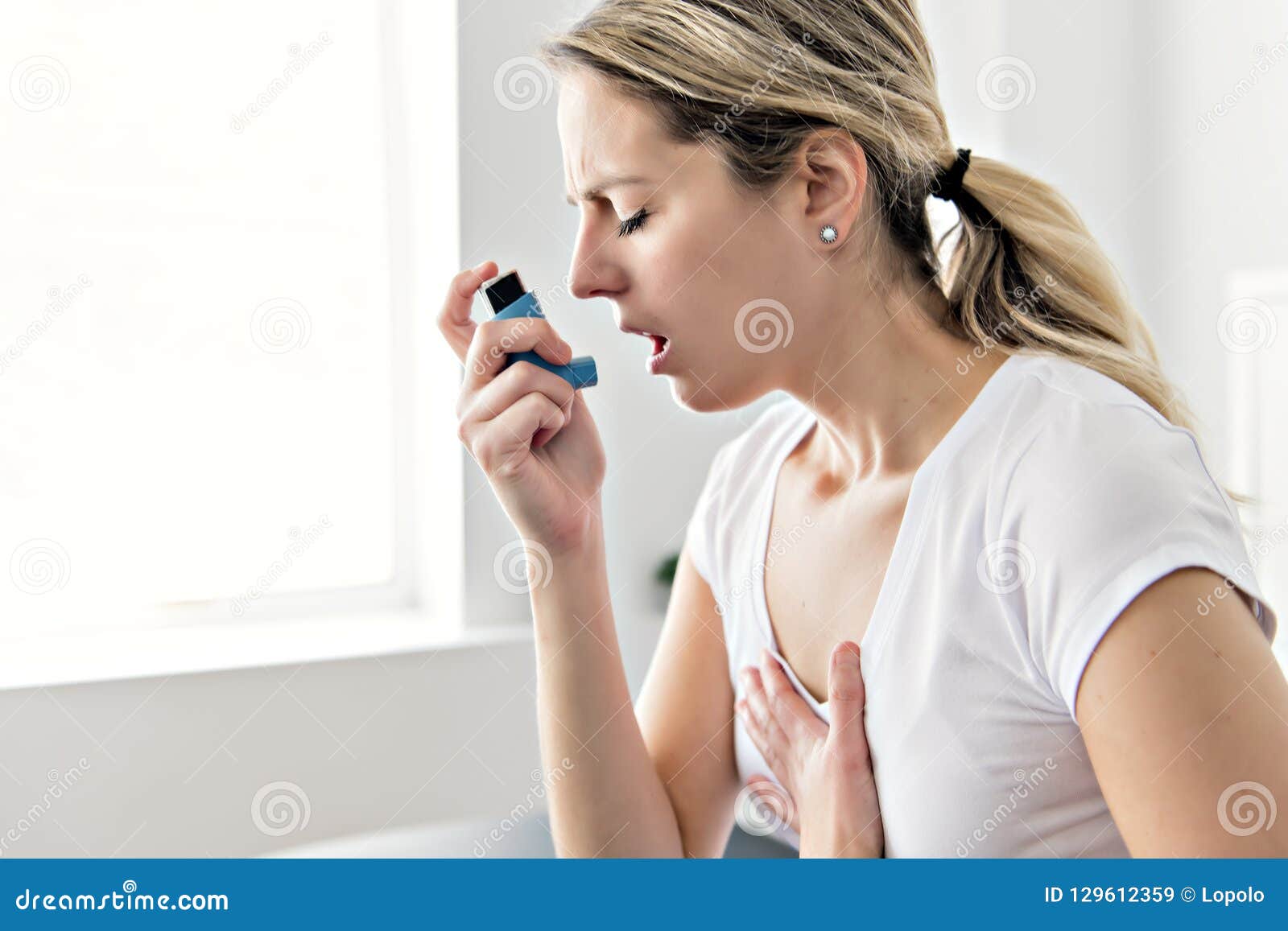 an asthmatic using her inhaler because of breath difficulties