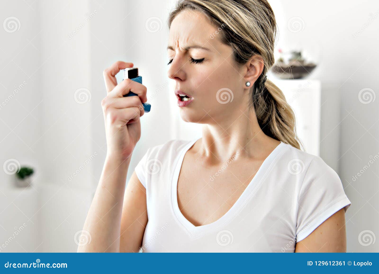 An Asthmatic Using Her Inhaler because of Breath Difficulties Stock