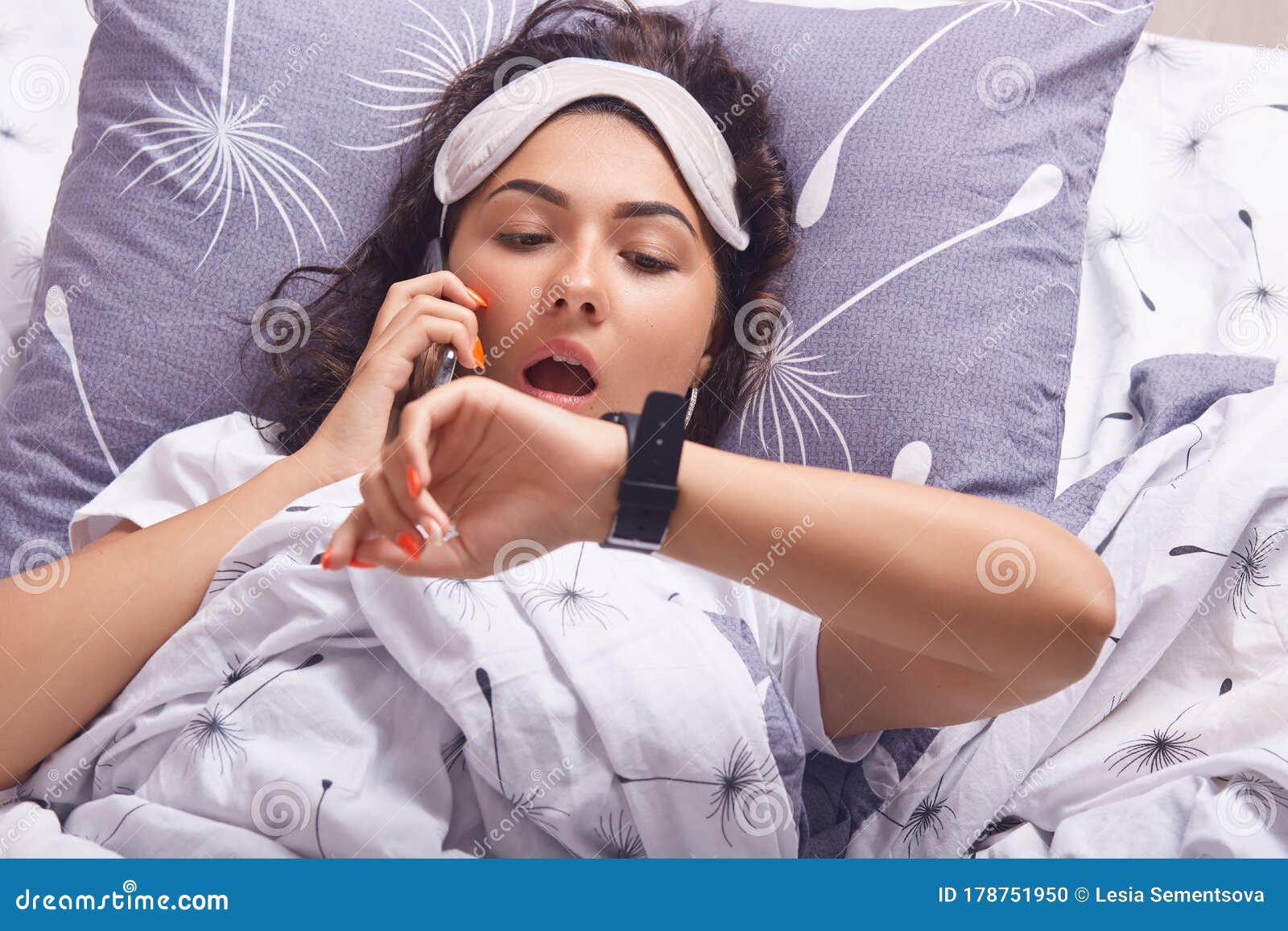 Astonished Woman Wearing Pajama And Sleeping Mask Posing With Opened Mouth Looking At Smart 
