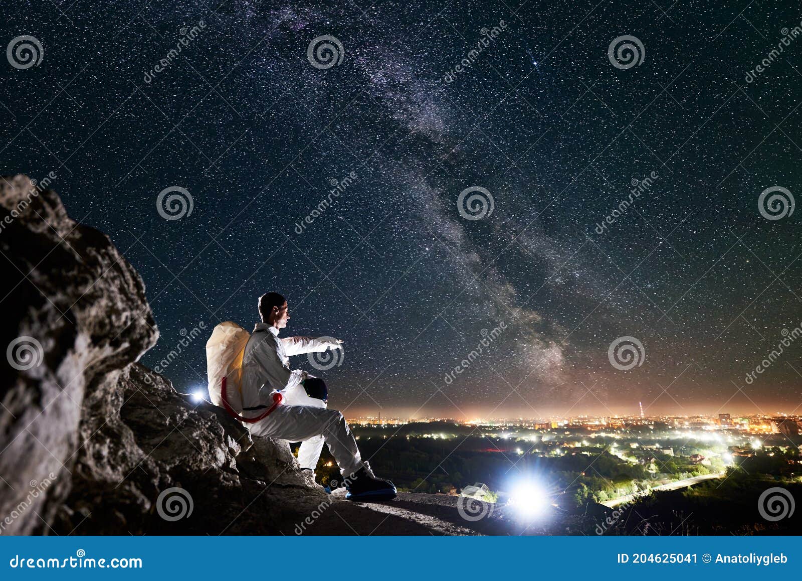 Astronauta Sentado En Una Colina Rocosa Bajo Un Hermoso Cielo Nocturno Con  Estrellas. Imagen de archivo - Imagen de viaje, brillo: 204625041