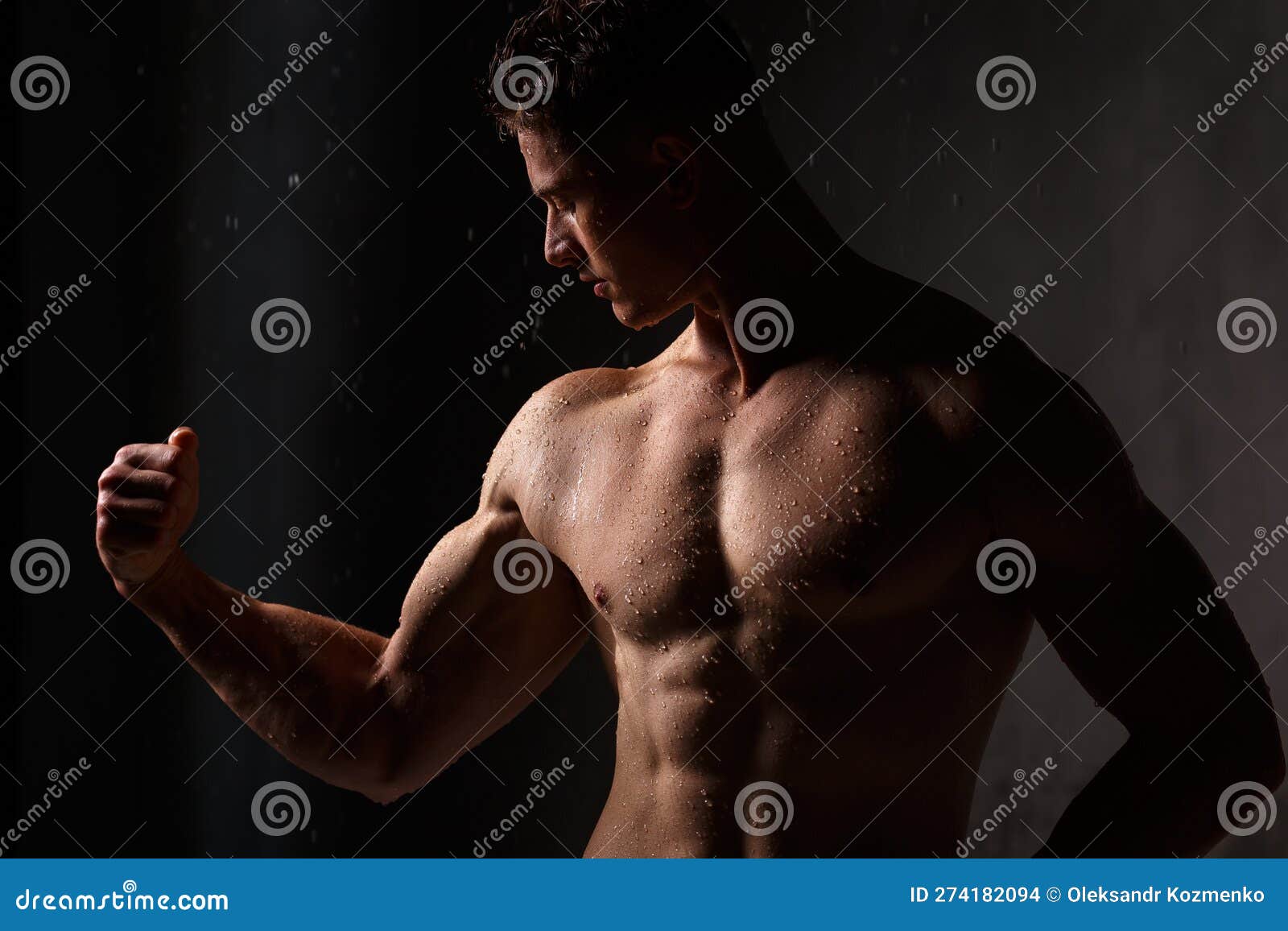 Athlete Bodybuilder Trains in the Studio in the Rain. Stock Photo