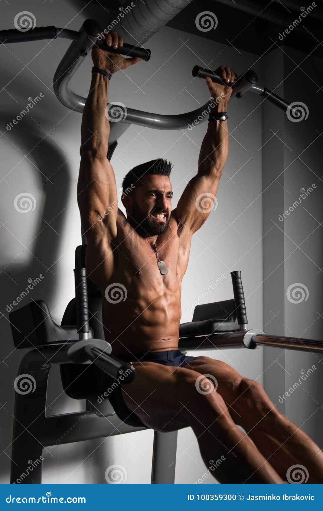 Athlete Doing Pull-up Bar Abdominal Exercise in Gym Stock Photo