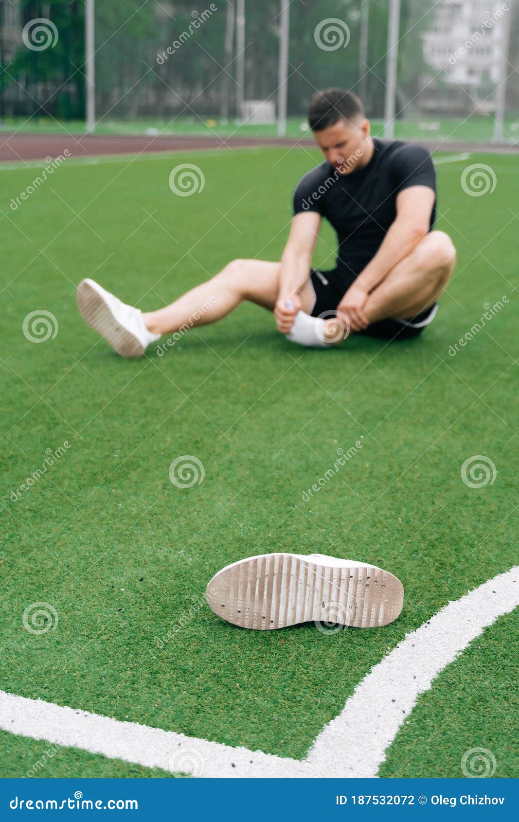 athlete on the football field holds his foot. dislocation of the foot or sprain of the joint