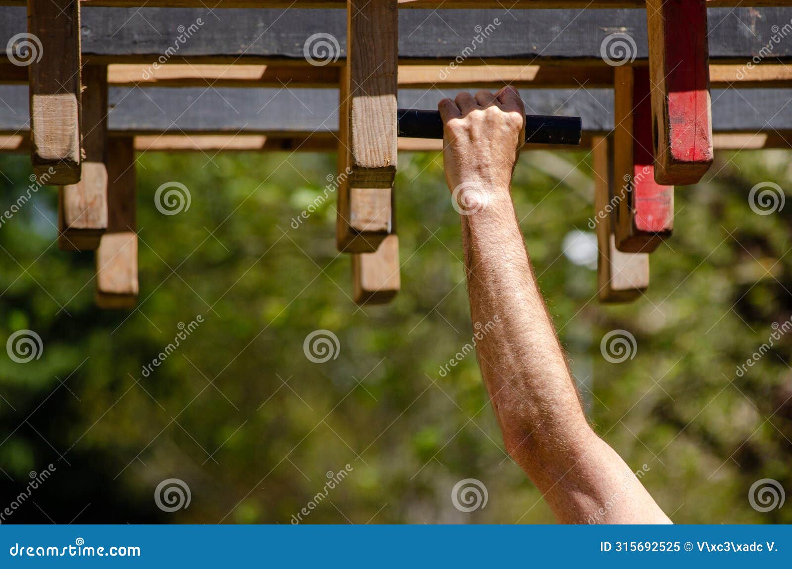 athlete hand at a hanging obstacle at an obstacle course race, ocr