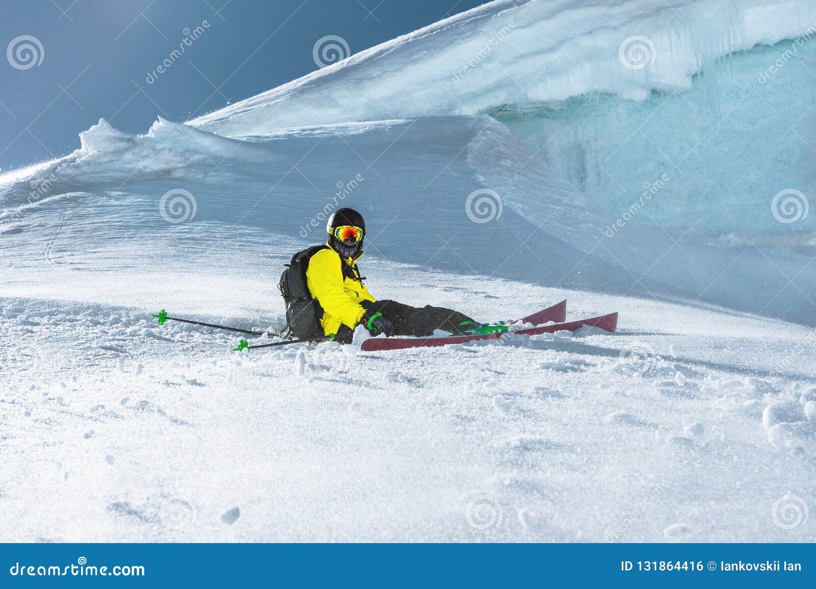 The Athlete Skier Sits on a Snowy Slope Against the Background of the ...