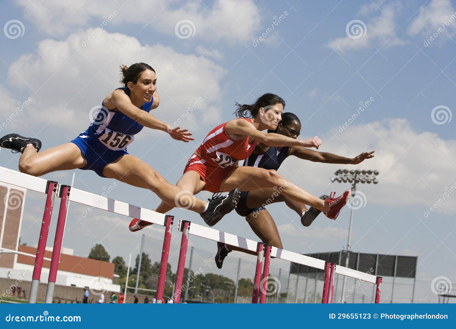 athletes clearing hurdles in race