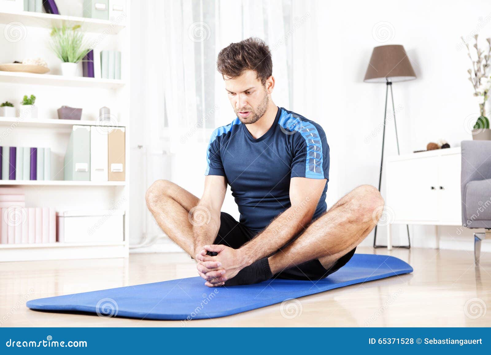 Athletic Man Doing Seated Adductor Stretch at Home Stock Photo - Image of  sporty, active: 65371528