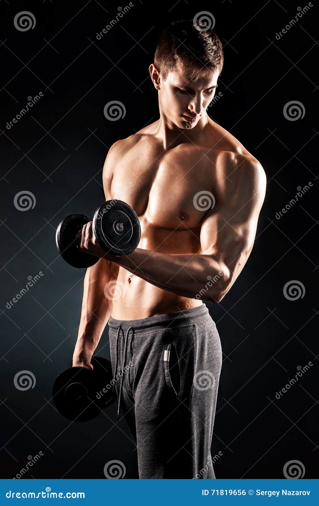 Strong Athletic Man Showing Muscular Body With Dumbbells 
