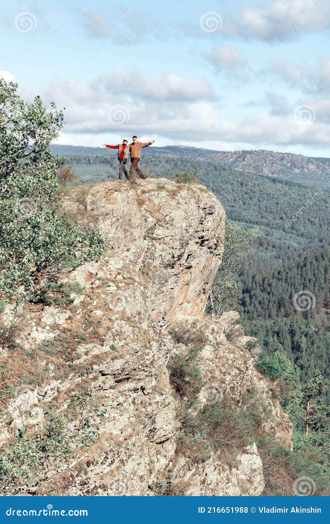 Athletic Mature Couple Stands On A High Rock Above The White River Against The Background Of The