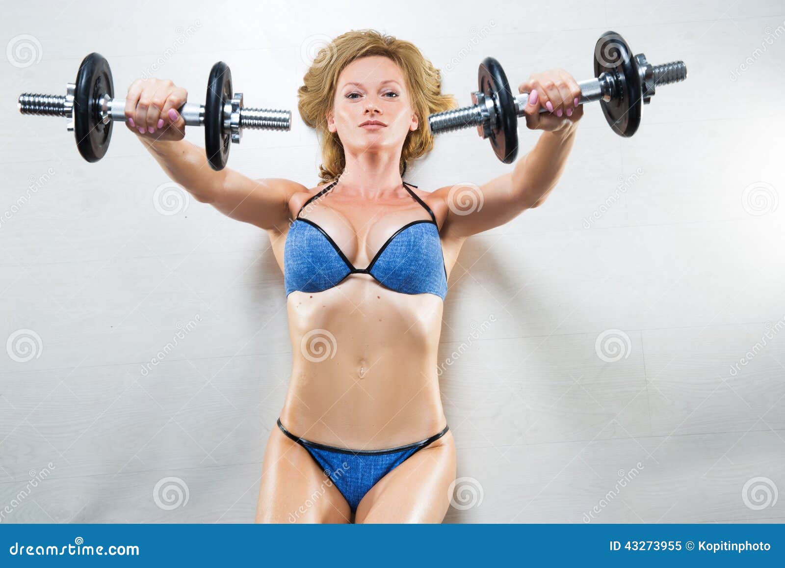 Athletic Woman Pumping Up Muscules with Dumbbells Stock Image