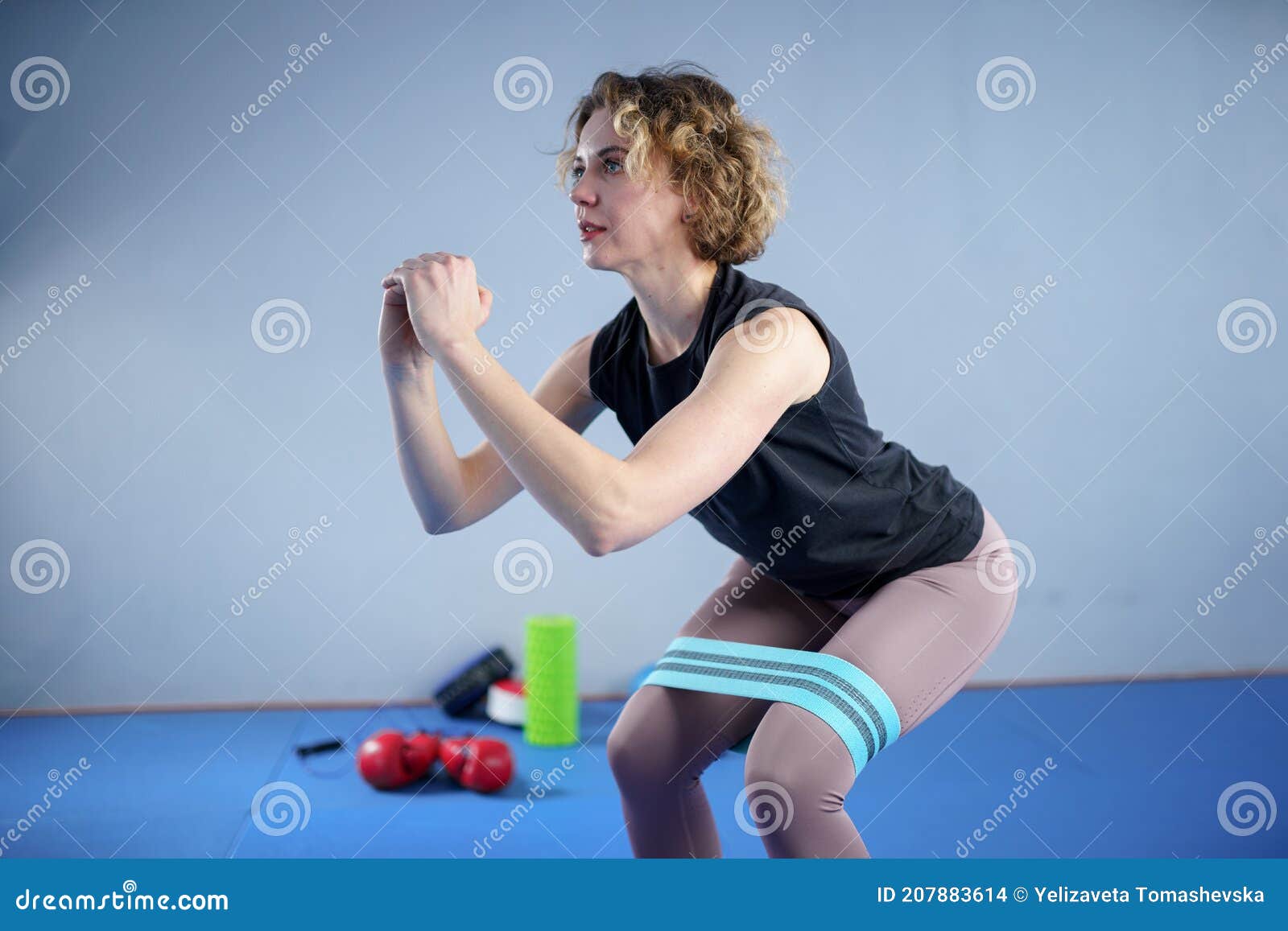 Athletic Woman in Sportswear Barefoot Using Thick Elastic Fabric