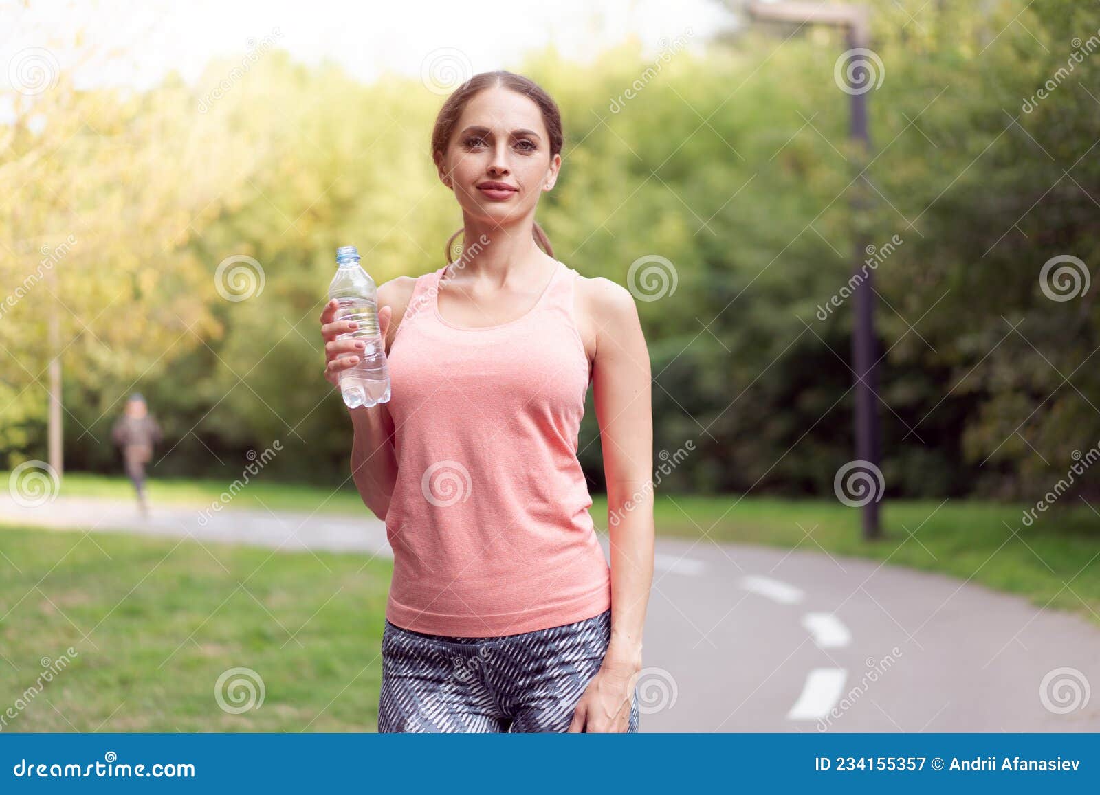 Atletische Vrouw Die Op Het Spoor Staat in Het Zomerpark Drinkt Water ...