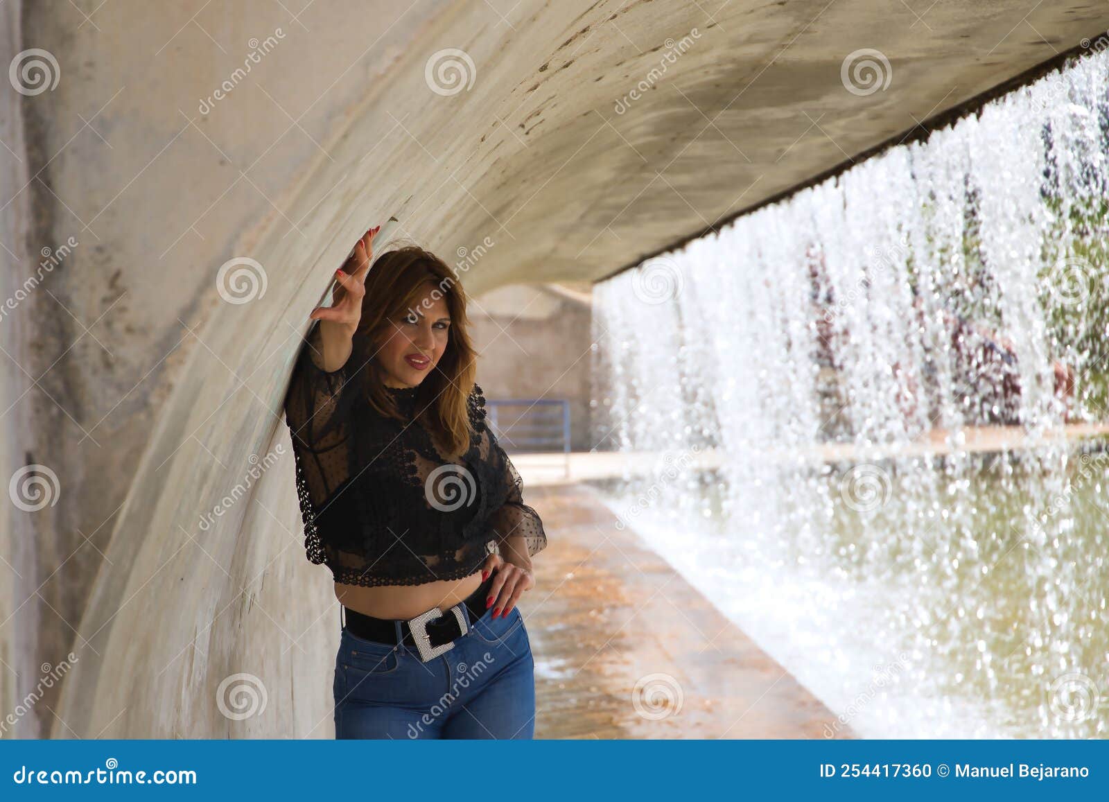Atractiva Mujer Madura Con Camisa Negra Transparente Y Jeans Posando Al Lado De Una Cascada En Una Actitud Sensual Foto de archivo - Imagen de deseo, 254417360