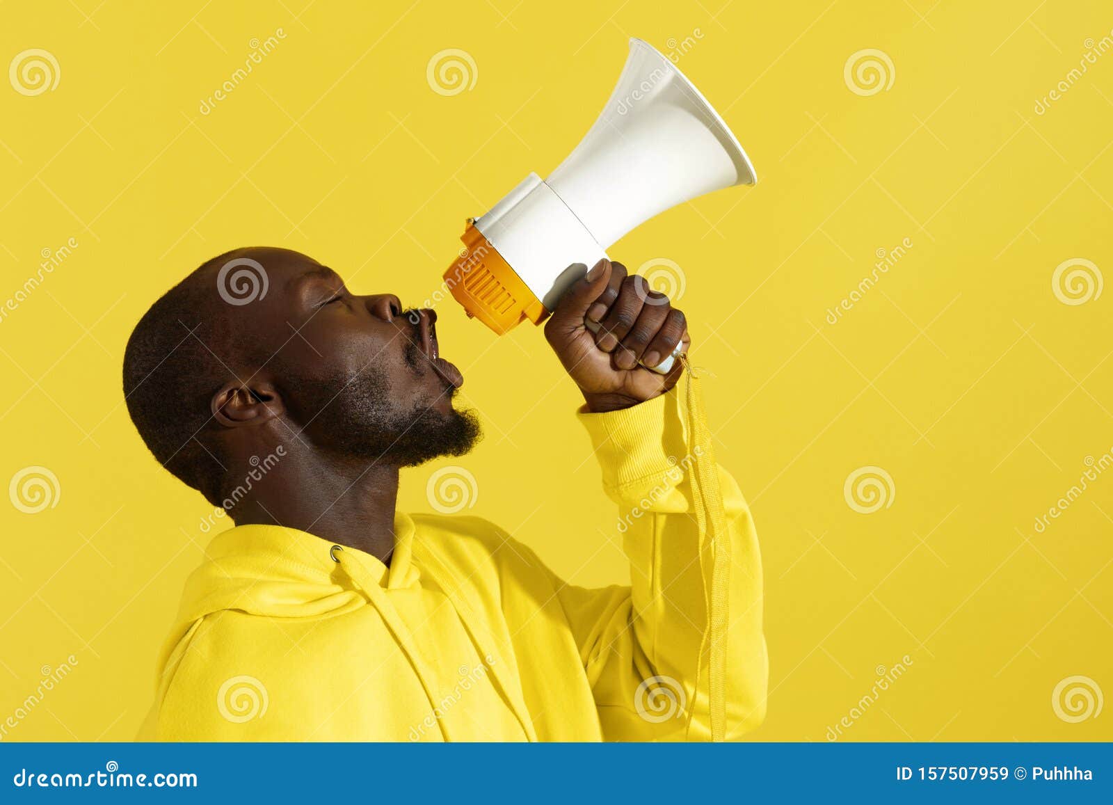 attention! black man shouting in megaphone on yellow background