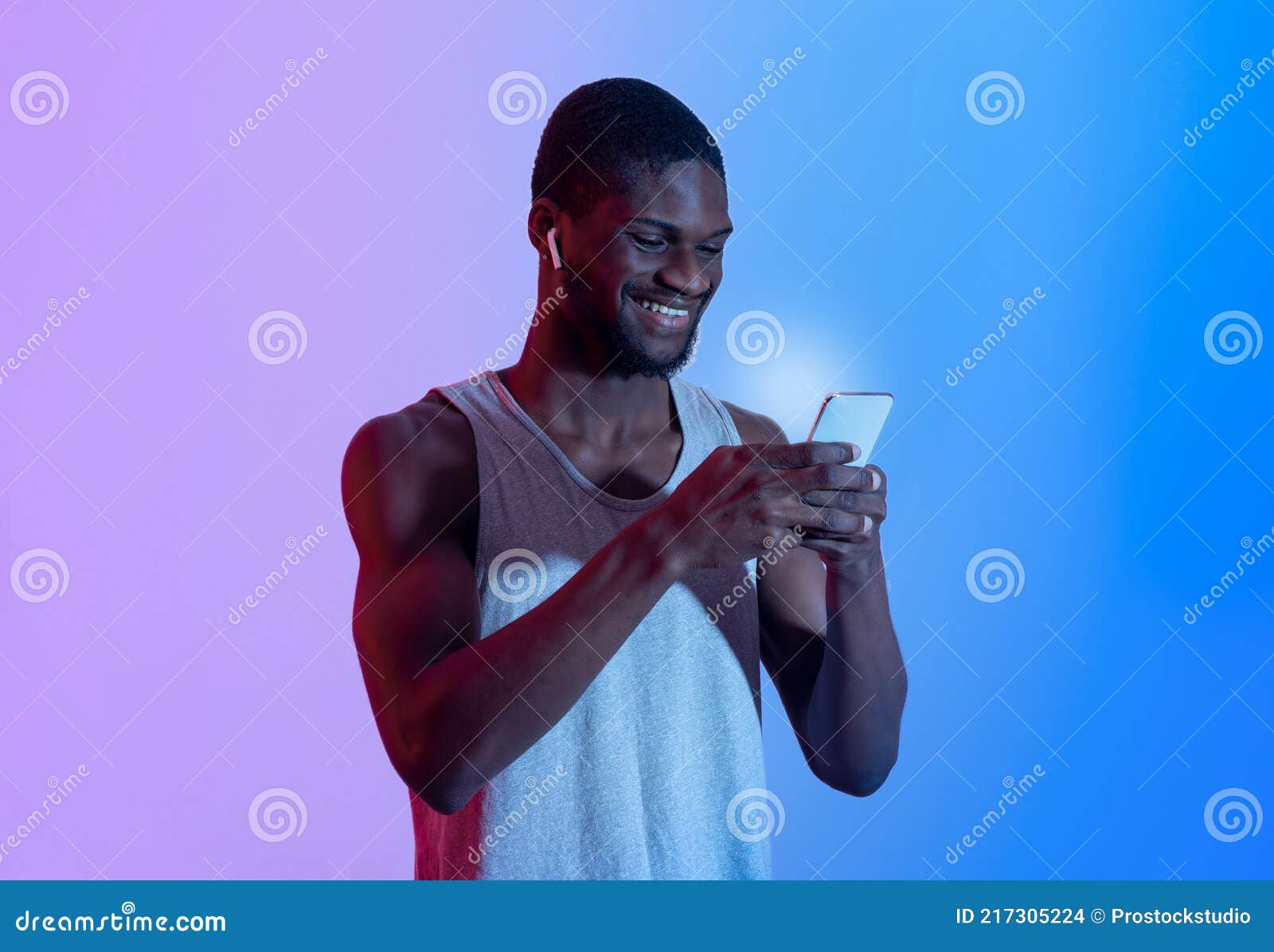 Attractive African American Guy With Cellphone Wearing Earphones