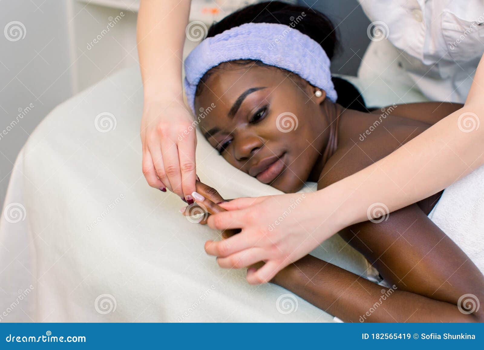 Attractive African Girl Having Massage Relaxing In Spa Salon Close To