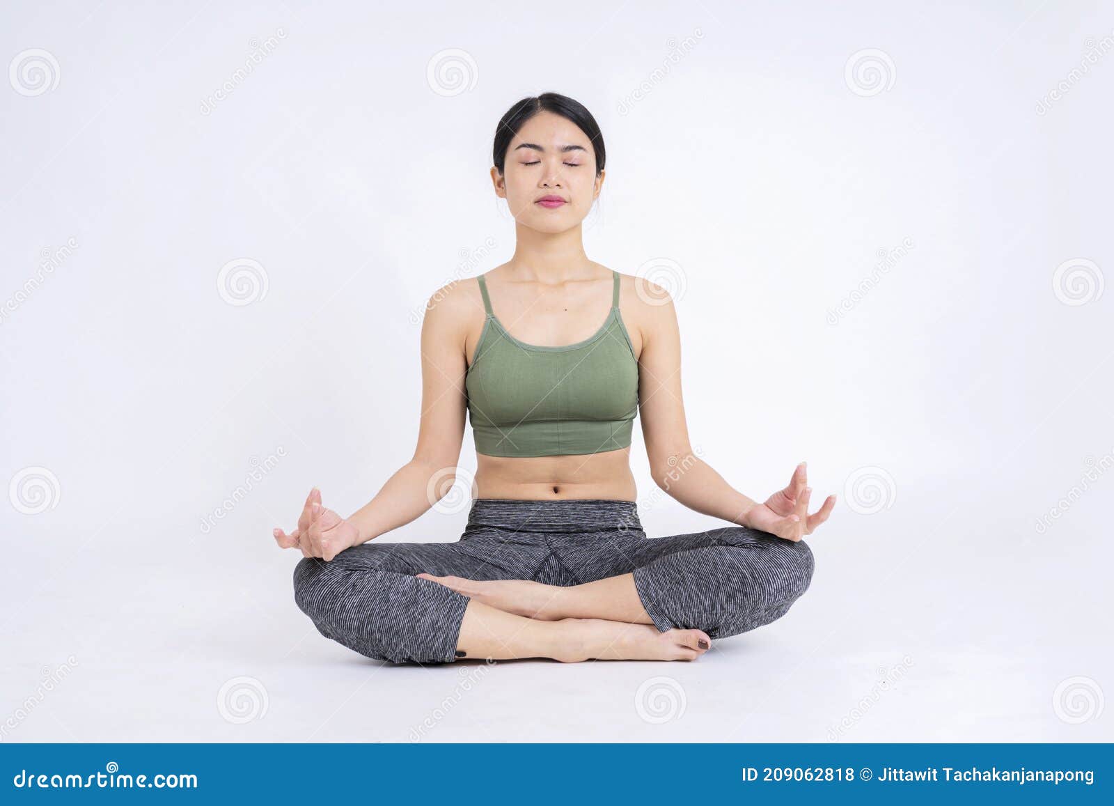 Woman doing yoga meditating in full lotus pose with hands in Namaste in  studio Stock Photo - Alamy