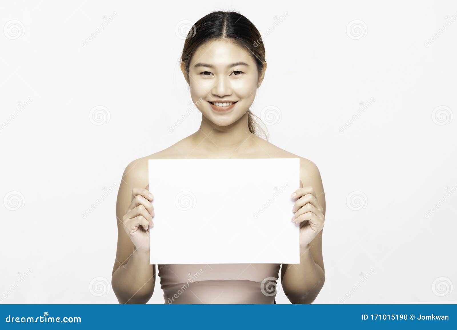 attractive asian young woman smile with holding blank paper for display text or cosmetics product