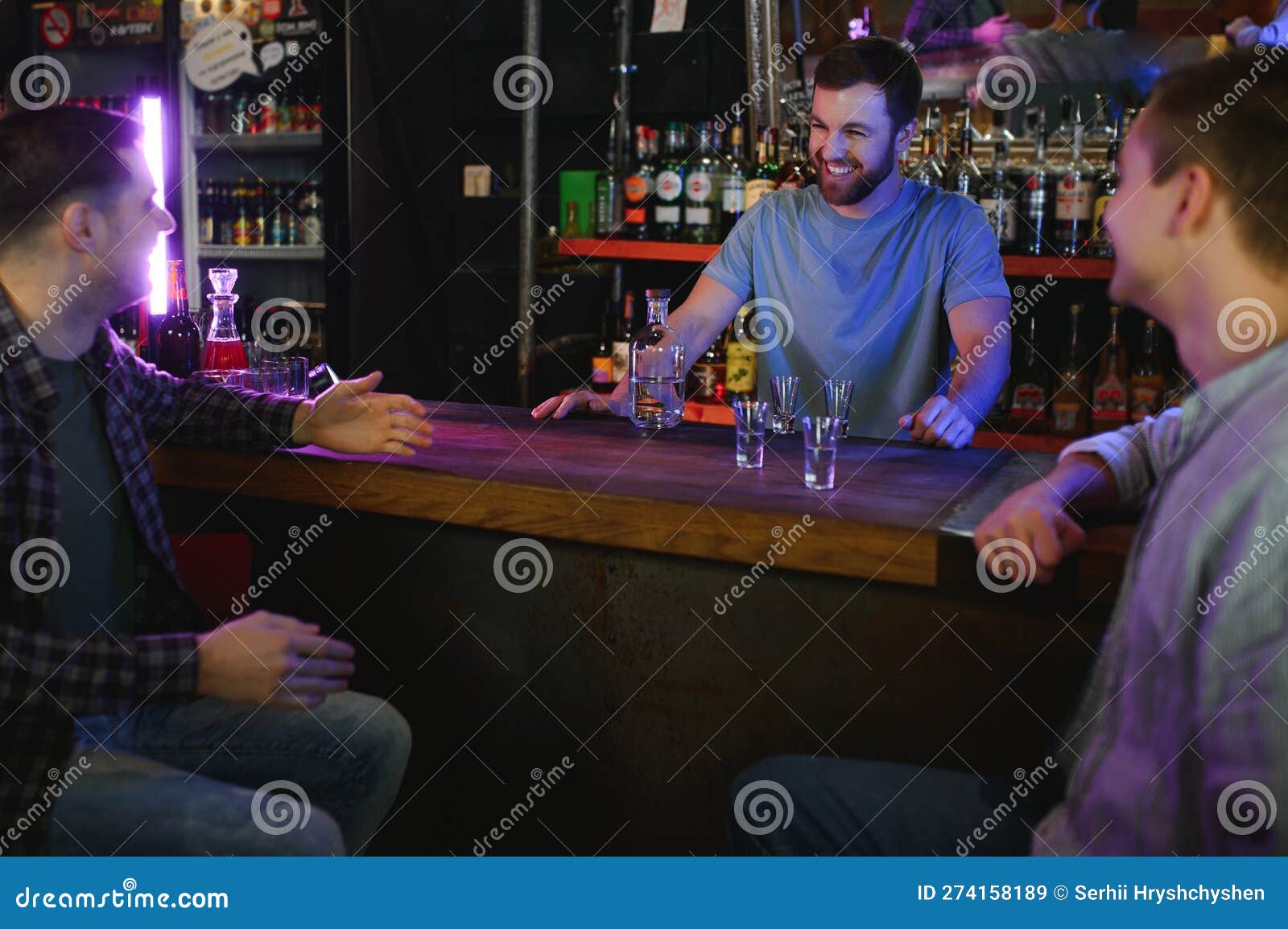 Attractive Bartender is Smiling and Taking Order of Two Men Sitting at
