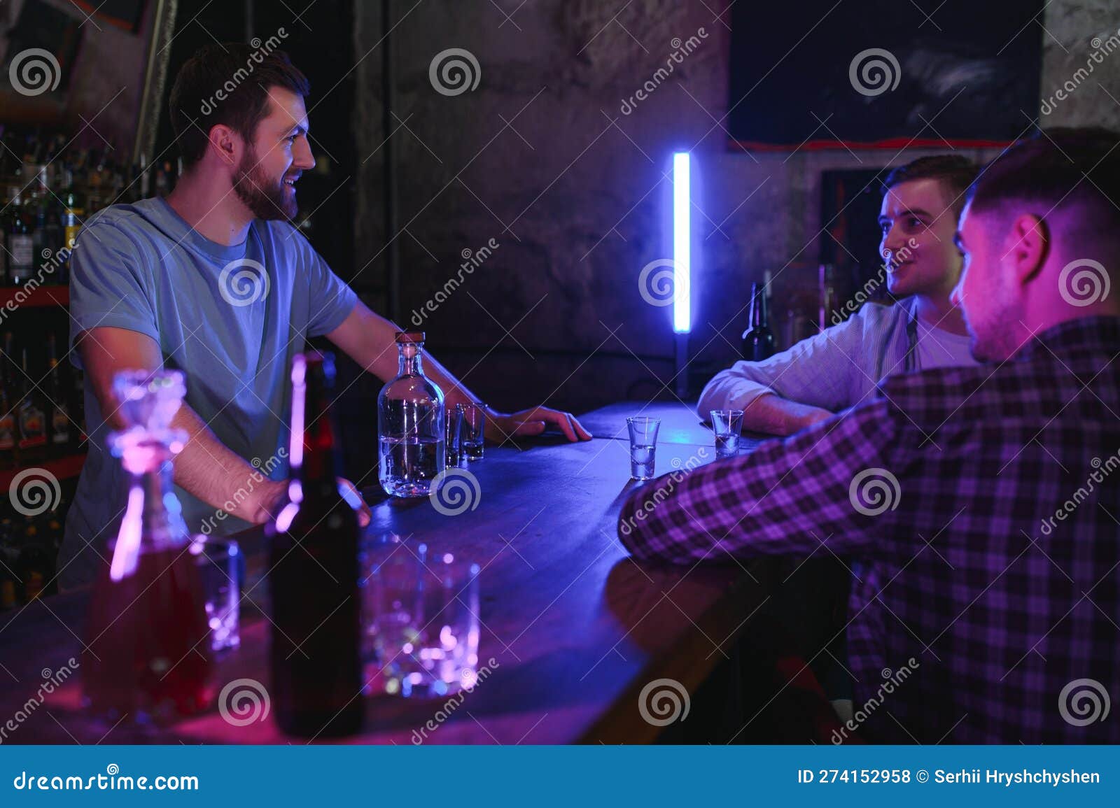 Attractive Bartender is Smiling and Taking Order of Two Men Sitting at