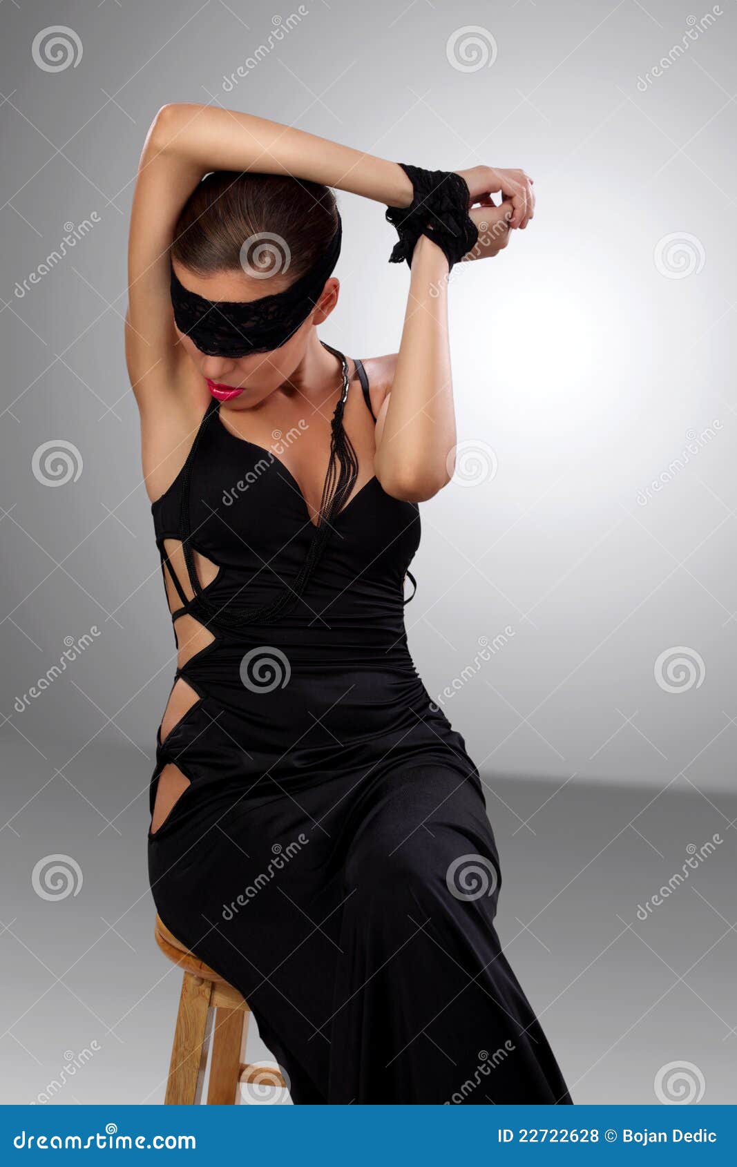 blindfolded woman sitting at a table - SuperStock
