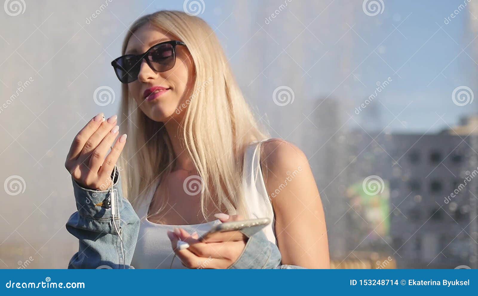 Attractive Blonde Smothers Music On Her Smartphone Outdoors Woman