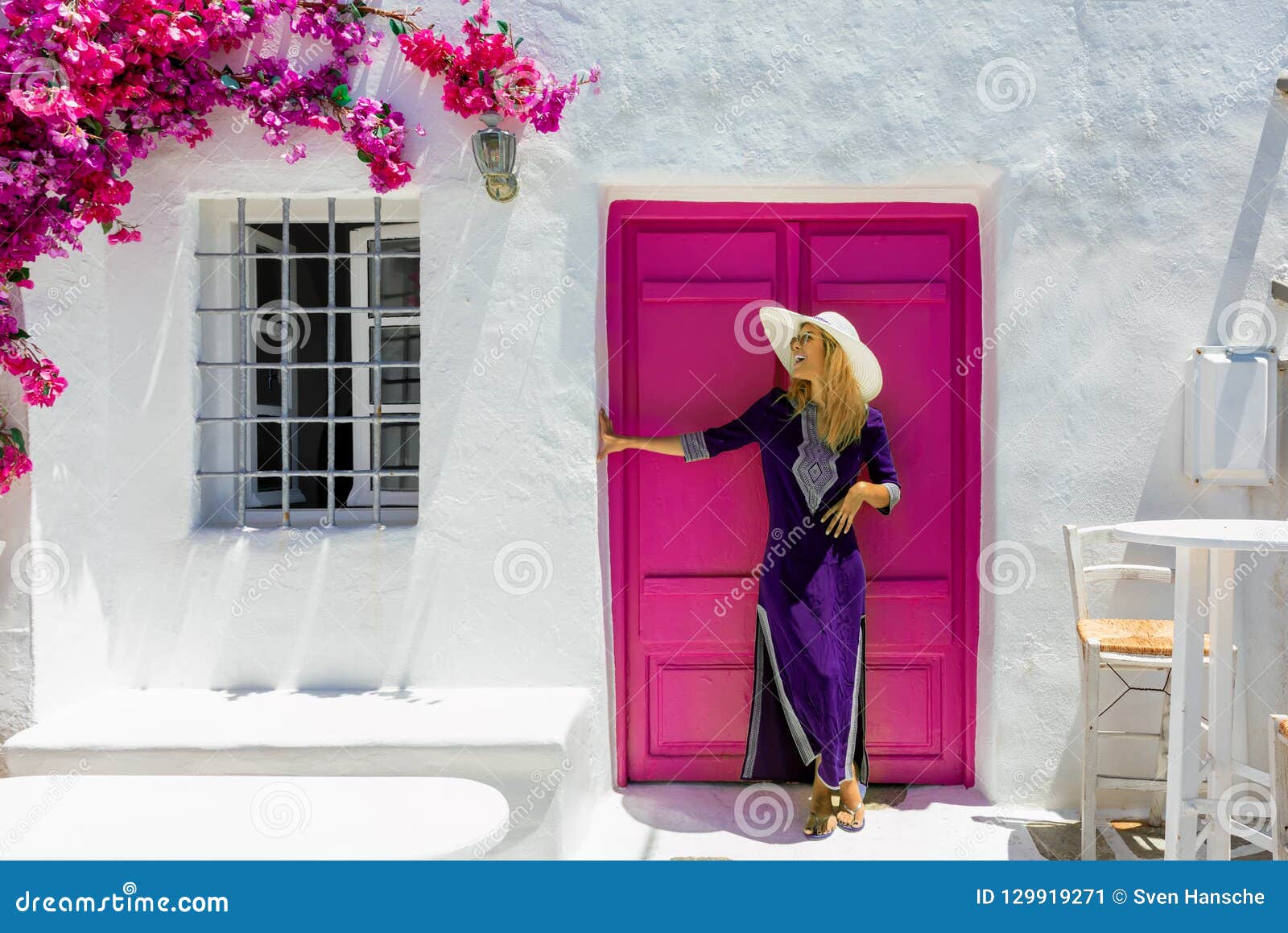 woman in front of a traditional cylcadic house in paros, greece