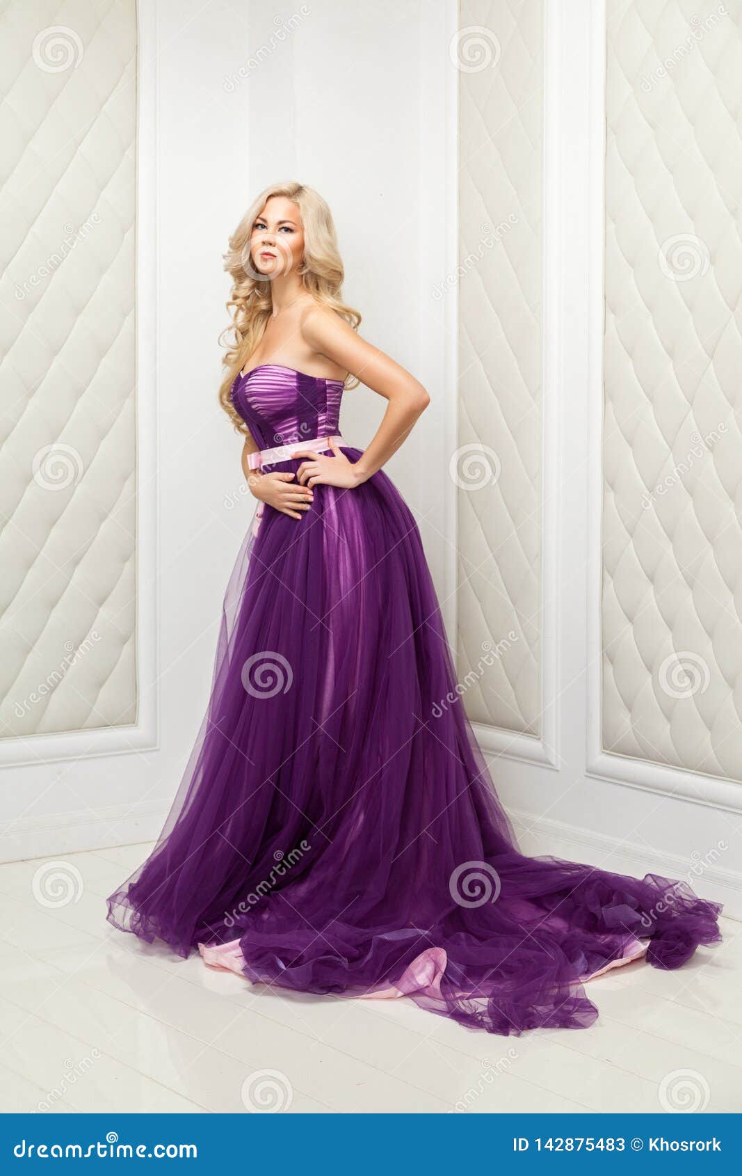 Attractive Blonde Woman in Fashionable Purple Classic Evening Dress with  Makeup and Long Wavy Hairstyle Standing and Posing Near Stock Image - Image  of interior, elegant: 142875483