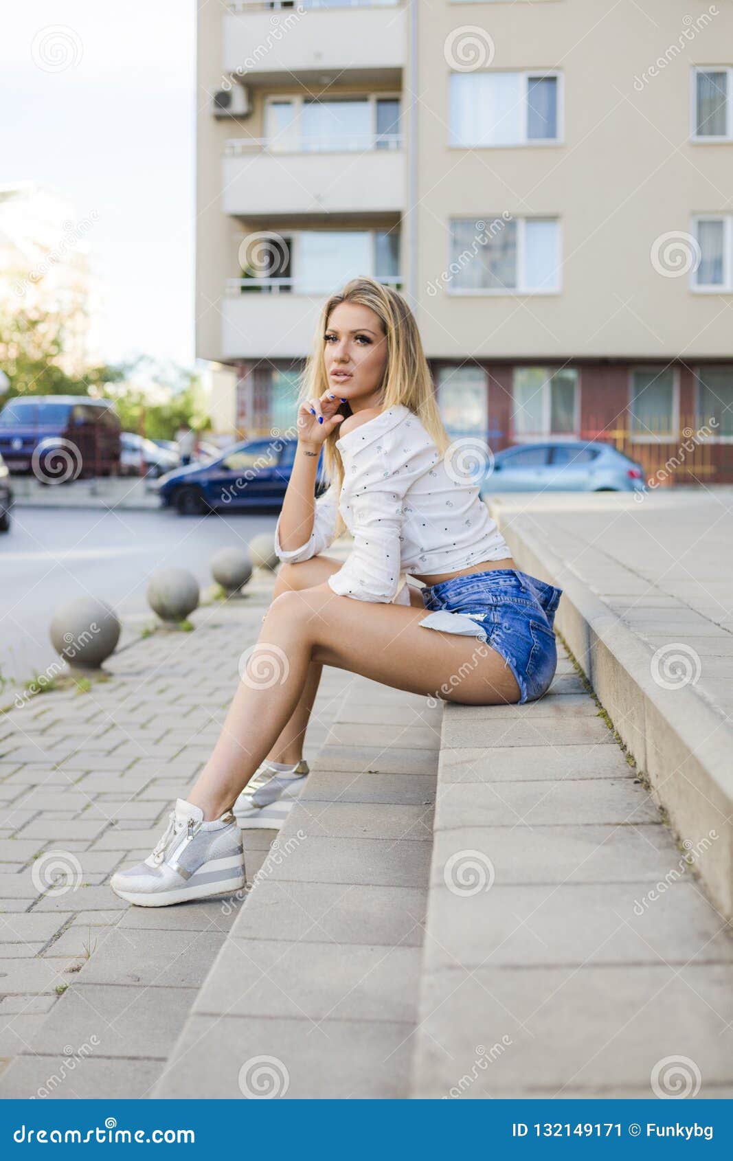 Attractive Blonde Woman In Stylish Clothes Sitting On Stairs At Street ...