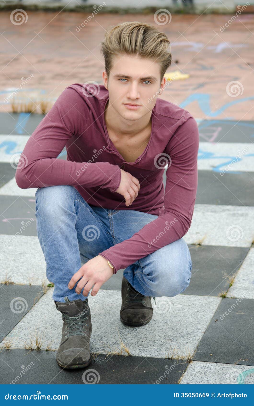 Attractive Blue Eyed, Blond Young Man Sitting on Checkered Floor Stock ...