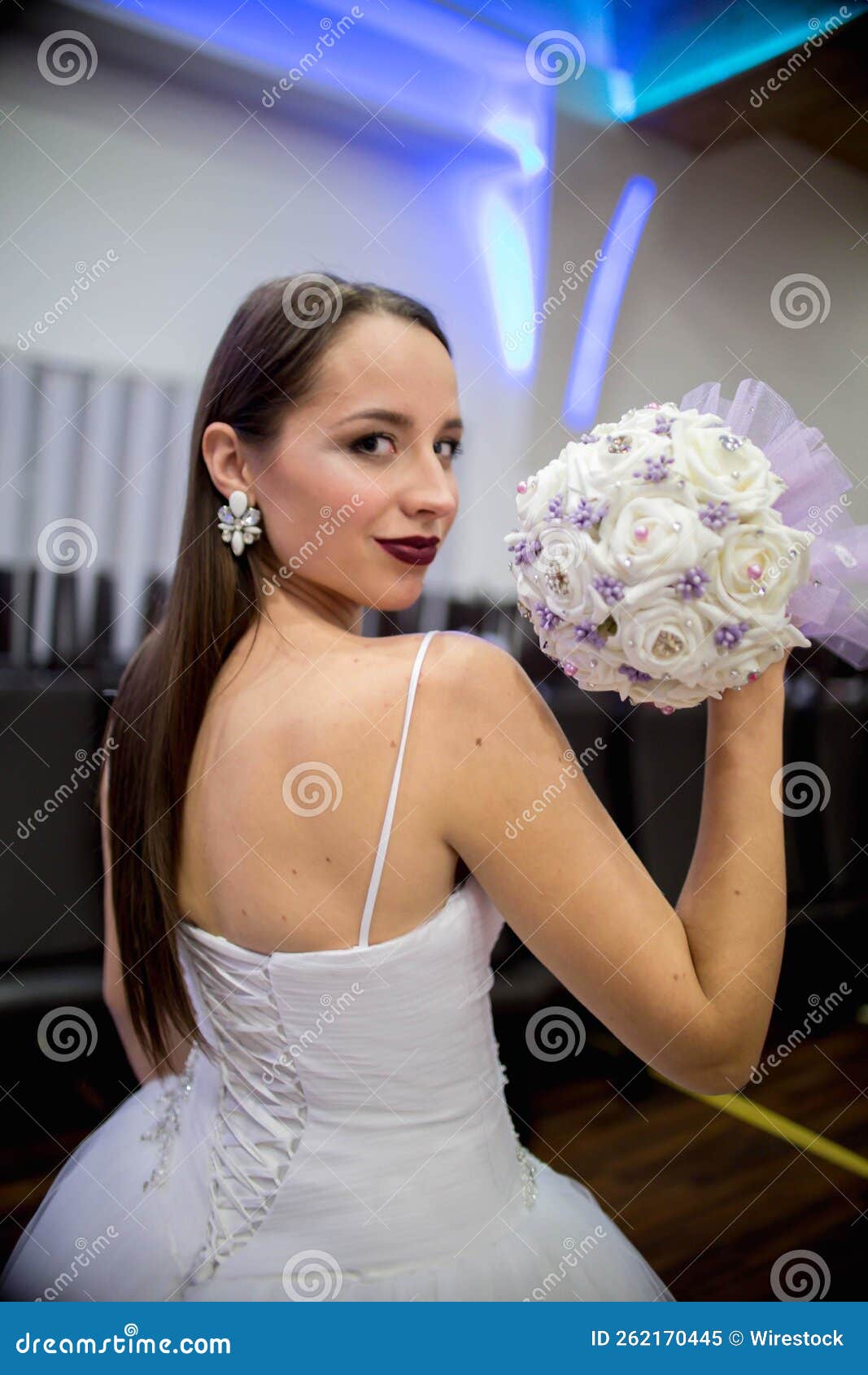 Premium AI Image  An elegant bride with a bouquet and a crown of flowers  poses for the camera at the outer door