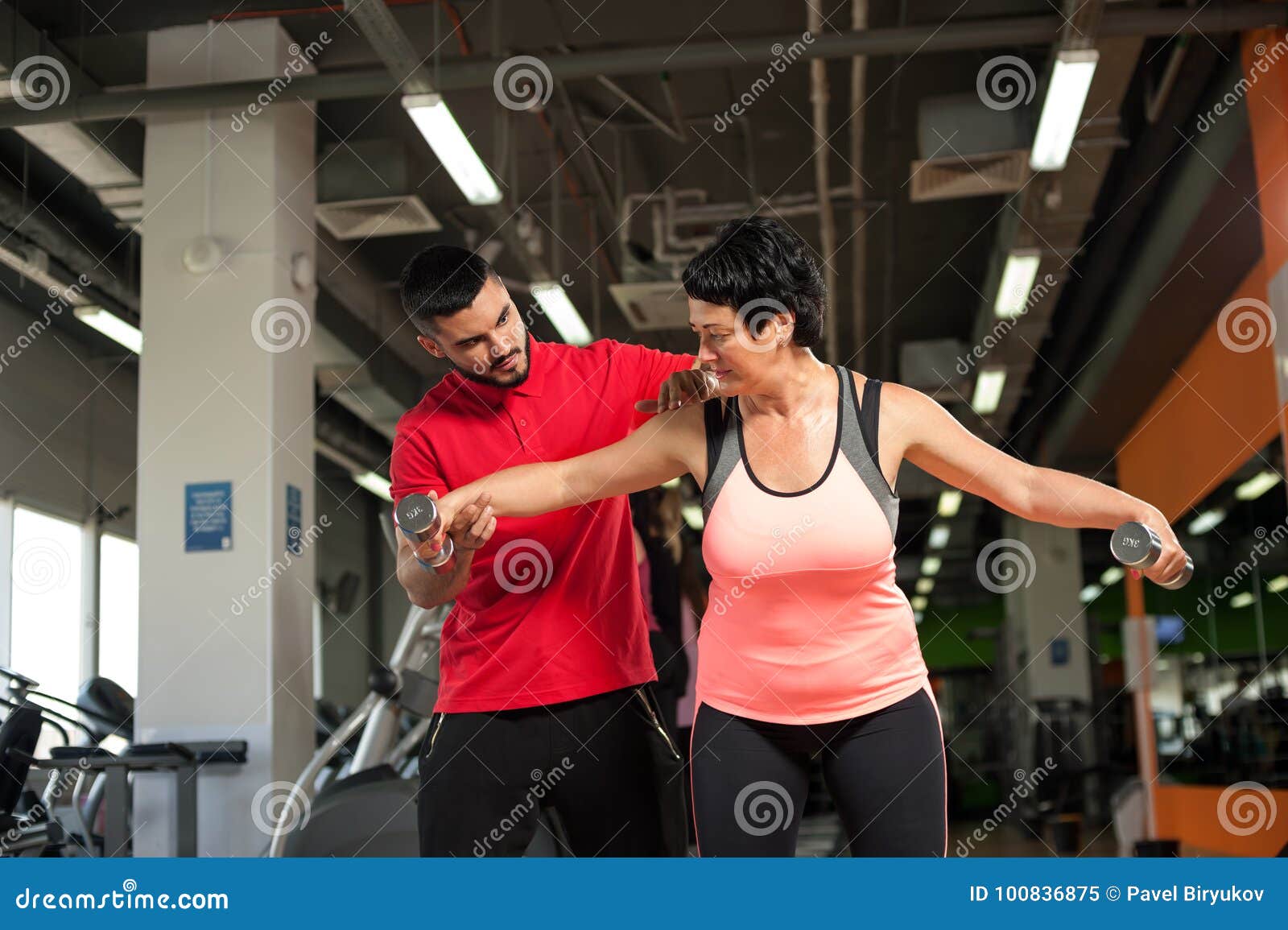 Fitness Coach Assisting His Female Client In Gym Stock Image Image Of